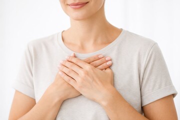 A serene woman with her eyes closed and a hand over her heart, embodying deep gratitude, self-love, and a state of emotional tranquility.