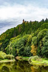Village path through rural summer landscape panorama of the G&oacute;ry Sowie (Owl Mountains), Poland, with green hills, meadows, forests, and clear blue sky in natural daylight.