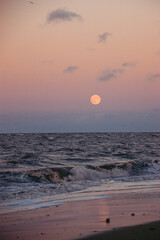 sunset on the beach with full moon beaming