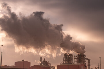 Fototapeta premium Industrial factory emitting smoke pollution into the atmosphere