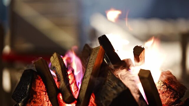 Burning firewood in metal brazier on snowy winter evening