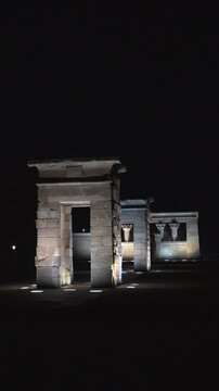 Madrid, Spain - December 30, 2025:  Templo de Debod - A group of stone pillars are lit up at night. The pillars are tall and have a dark color. The scene is quiet and peaceful.