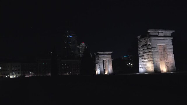 Madrid, Spain - December 30, 2025:  Templo de Debod. A city at night with a large building in the background. The city is lit up with lights and the sky is dark.