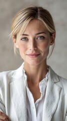 A woman in a white blazer posing for a picture