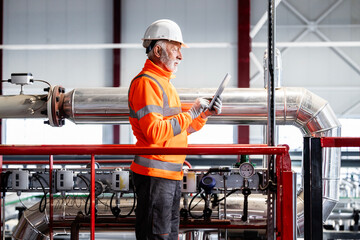 Senior engineer worker reviewing industrial factory pipes