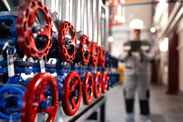 Engineer worker inspecting industrial pipeline valves in factory