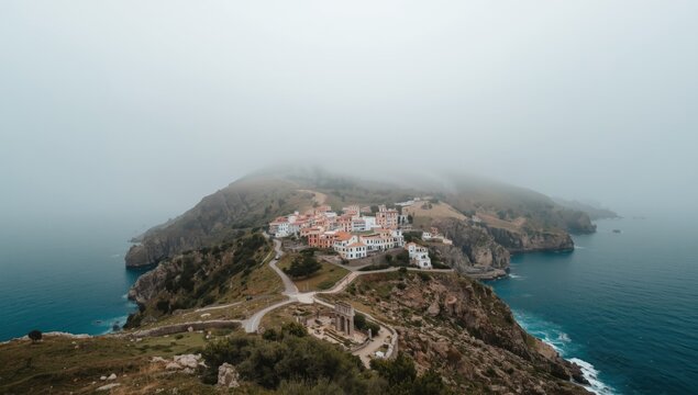Wide-angle of a contemporary village situated above a derelict town on Sardinia's east coast, highlighting urban renewal and historical preservation
