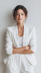 A woman in a white suit with her arms crossed
