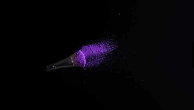 Makeup brush with purple powder dust on a dark surface, utilized for makeup artistry and color mixing
