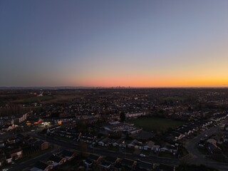 Fototapeta premium Aerial sunset view of the Greater Manchester skyline with suburban housing and open parkland with views towards the city skyline in the distance. Manchester England. 