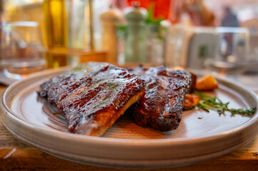 Grilled barbecue ribs with roasted potatoes served on rustic plate