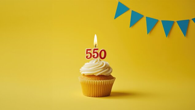 Number 550 birthday candle and cupcake arrangement on bright yellow surface accented by blue pennants, event decor