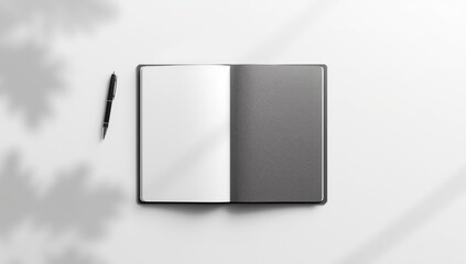 Flat lay of a grey notebook, pen, and open white page setup for creative planning, layout background