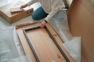 Middle ages woman assembles furniture at home