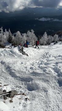 People hiking to Debela pec in winter