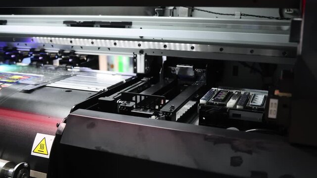 Industry printer. High quality Industrial inkjet printer in operation. printing patterns on large sheet of fabric or paper. Automate printer for modern textile printing and digital print technology.