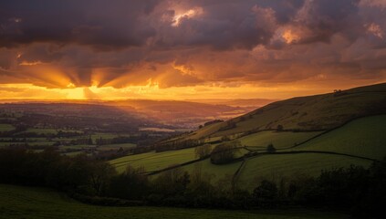 Scenic rural landscape featuring hills and valleys bathed in sunset light with dynamic cloud formations, suitable for nature backgrounds