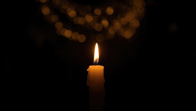 Dark night with a glowing candle flame serving as background decor in religious events and birthday parties, ambient illumination - Powered by Adobe