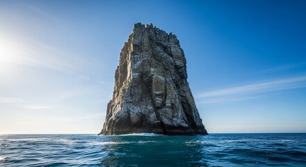The Majestic Sea Stack: A solitary sea stack rises majestically from the tranquil ocean waters under a vast, cerulean sky, creating a scene of serene beauty and timelessness. 