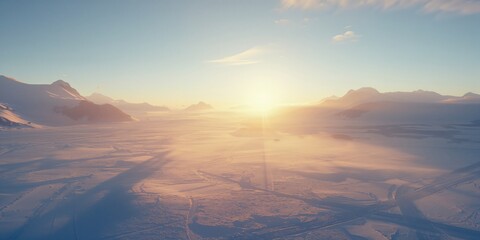 Morning sun rises behind snow-covered mountains, illuminating the rugged terrain, winter landscape, seasonal change