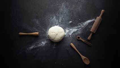Floured dough and baking tools arranged on a dark surface, emphasizing home baking activities, National Baking Week