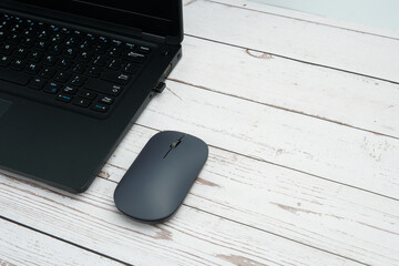 Modern business workspace with laptop and mouse on white wooden desk representing productivity, digital work, office environment, and professional setup with clean copy space.