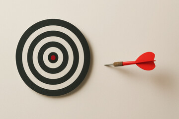 Dartboard with a single dart far from the center on a neutral background, symbolizing failure and missed opportunities with copy space