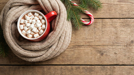Cozy mug of cocoa with mini marshmallows and knitted scarf