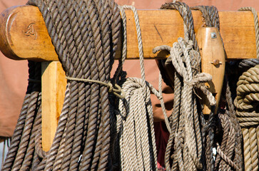 Coiled ropes on a carved post and beam of a viking ship replica.