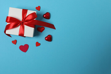 Festive background with a bottle of champagne, two glasses and hearts and gift boxes. A romantic...
