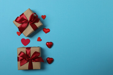 Festive background with a bottle of champagne, two glasses and hearts and gift boxes. A romantic...