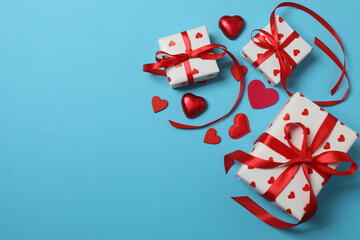 Festive background with a bottle of champagne, two glasses and hearts and gift boxes. A romantic...