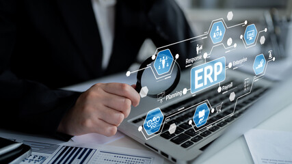 A business professional uses a laptop to explore ERP system features, emphasizing efficient management of enterprise resources and data-driven decision-making. Tessel