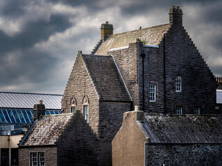 Scottish stone building featuring crow-stepped gables under cloudy sky