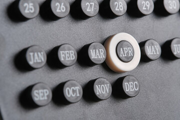 Month April on stylish black calendar, close up.