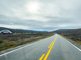 Norwegian scenic route winding through a mountainous landscape under a cloudy sky