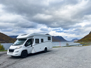 A motorhome parked by the road in the autumn landscape of the Lyngen Alps, Northern Norway, with mountains.