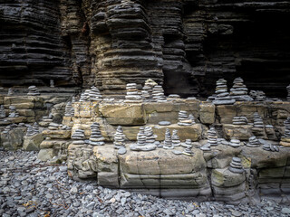 Rock cairns creating balance on cliff with pebbles