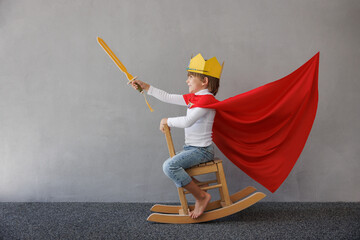 Funny child pretend to be knight. Happy kid having fun at home
