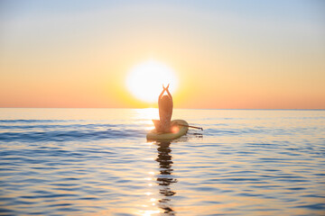 Young woman walking on stand up paddle sup boards by the sea during summer vacation