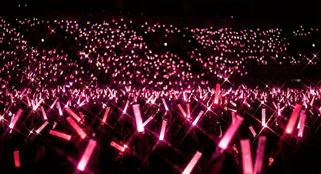 ライブ会場で輝くピンクのペンライトの海　生成AI