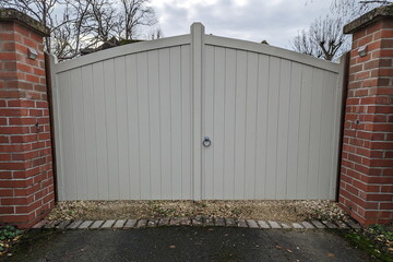 Large wooden gates at the entrance of a house driveway