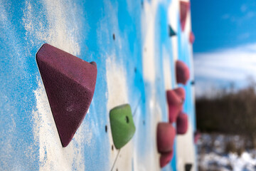Colorful grips on a climbing wall. Sports and recreation.
