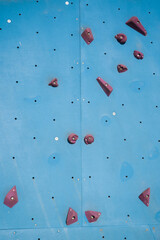 Colorful grips on a climbing wall. Sports and recreation.
