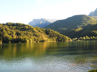 Beautiful lake surrounded by lush greenery in the Tuscan countryside, Italy. Scenic rural landscape with calm water, rolling hills, and natural vegetation, capturing the peaceful and idyllic