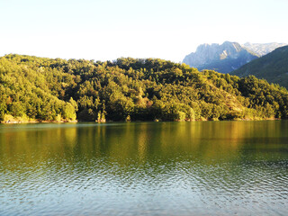 Beautiful lake surrounded by lush greenery in the Tuscan countryside, Italy. Scenic rural landscape with calm water, rolling hills, and natural vegetation, capturing the peaceful and idyllic