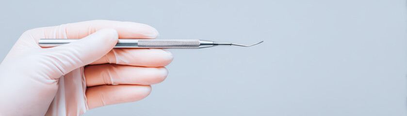 Dental tool held by gloved hand close up, minimal style with soft lighting and clean background, showing precision and care in dental practice