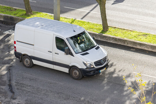 White mercedes benz sprinter van driving on street