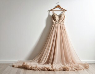 Elegant beige wedding dress hanging on wooden hanger