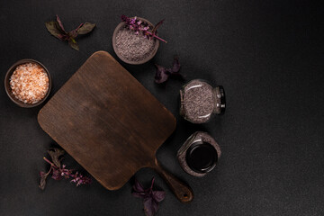 Brown cutting board with pink and black salt bowls